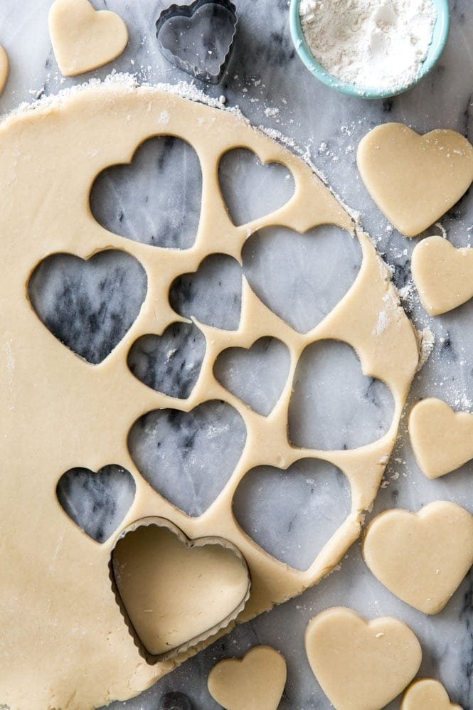 How to make CREAM CHEESE SUGAR COOKIES! OMG these are so thick and soft and the cream cheese makes them out of this world! #sugarocokies #cutoutcookies #valentinesdaydesserts cream cheese sugar cookie dough rolled out and cut into hearts
