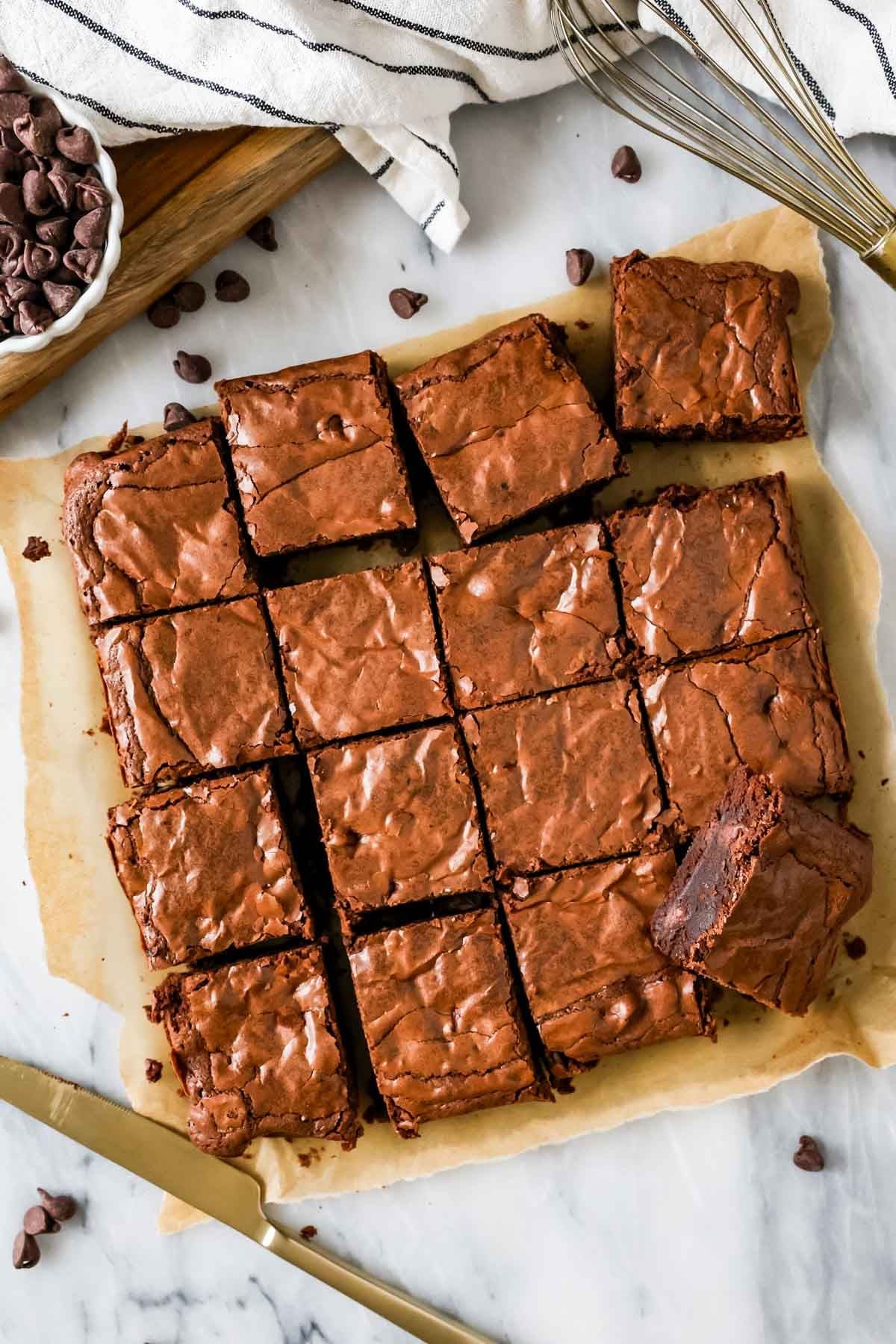 Overhead of my homemade brownie recipe cut into squares with chocolate chips and lined towel in background.
