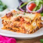 Closeup of finished lasagna showing the layers on a white plate