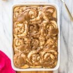 Baking dish full of caramel-glazed apple cinnamon rolls