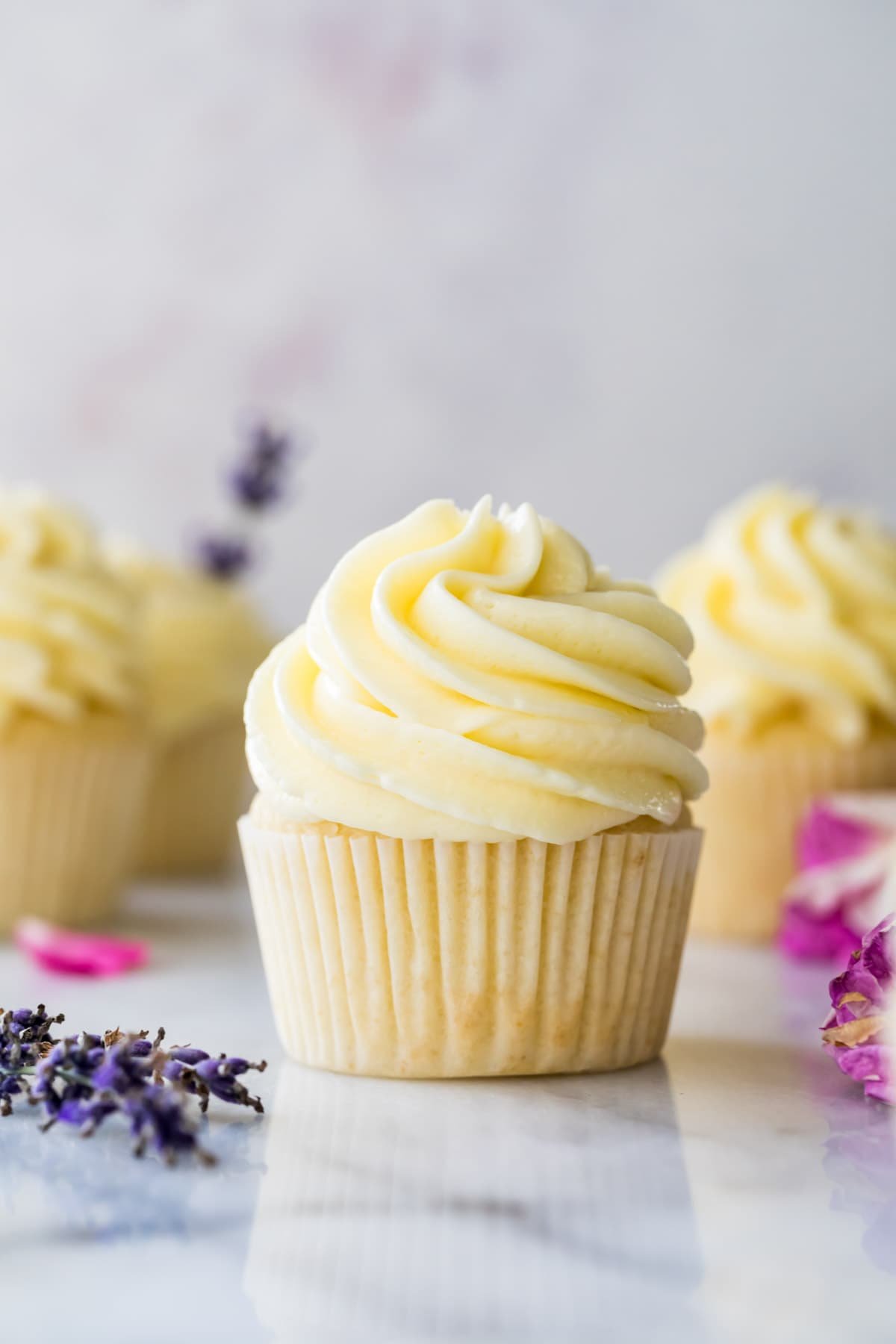 Cupcake topped with German buttercream frosting surrounded by other cupcakes