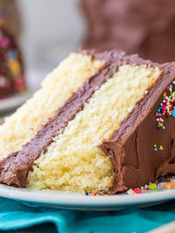 one bite missing from a slice of vanilla cake with chocolate frosting