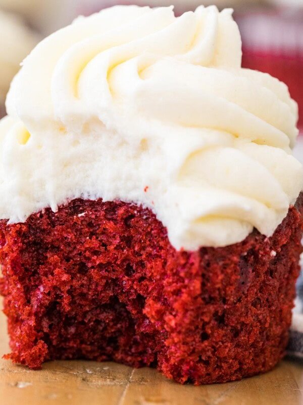 Red velvet cupcake with one bite missing.