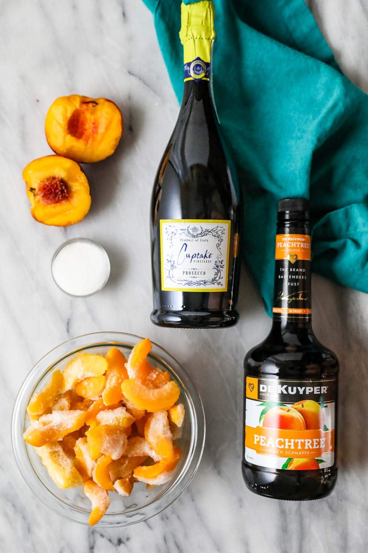 Overhead view of ingredients including frozen peaches, peach schnapps, and more.