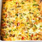 Close-up view of a breakfast casserole that's been cut into squares.