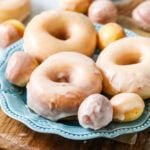 Plate of sourdough donuts and donut holes that have been dipped in a vanilla glaze.
