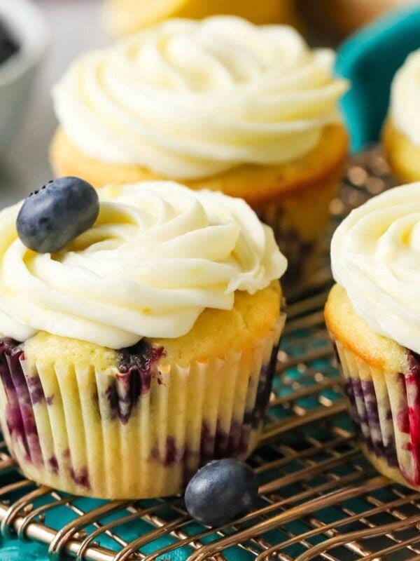 Lemon blueberry cupcakes on a cooling rack.