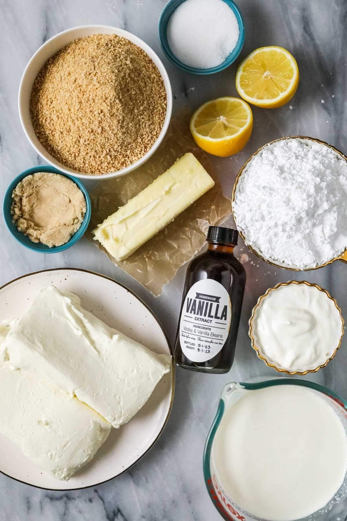 Overhead view of ingredients including cream cheese, graham crackers, lemon, and more.