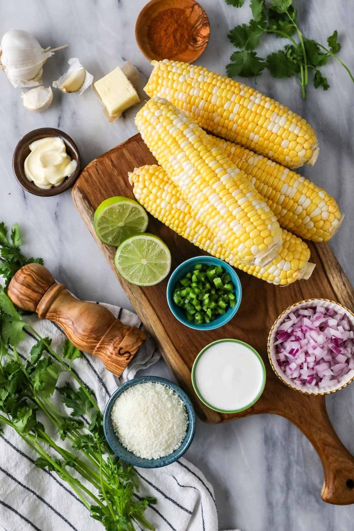Overhead view of ingredients including corn, lime, cilantro, crema, and more.
