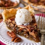 Slice of pecan pie with ice cream on top.