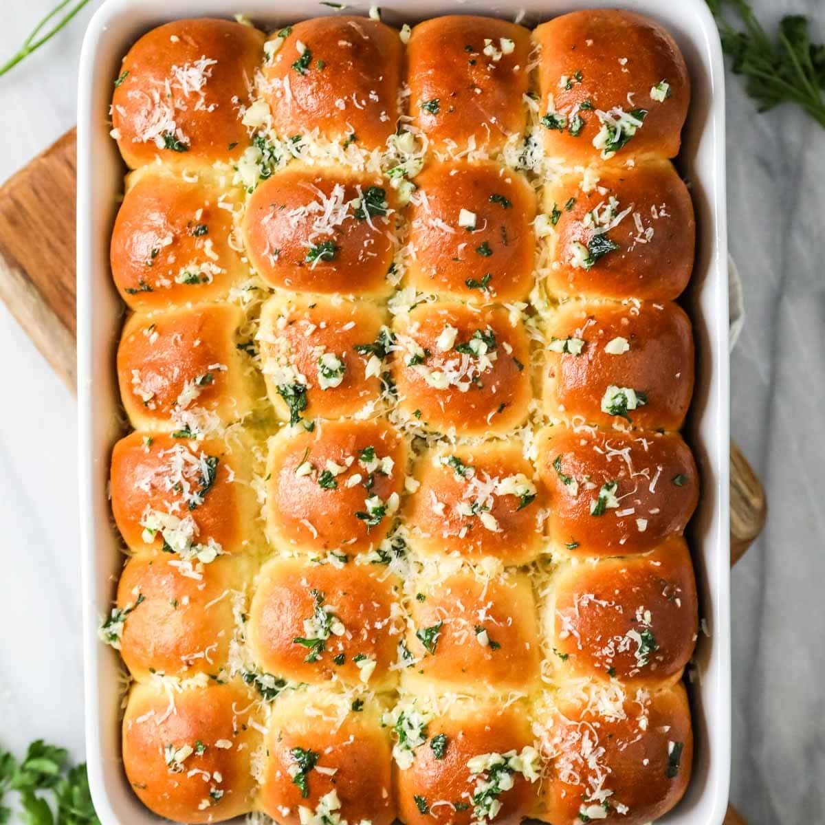Overhead view of a pan of garlic bread dinner rolls.