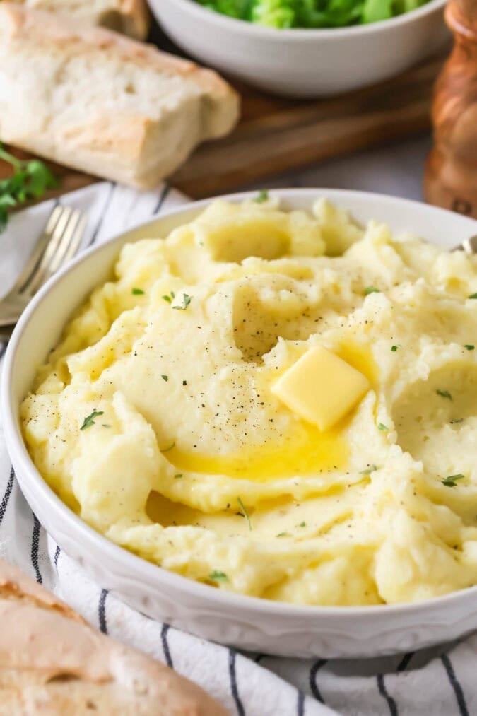 Bowl of mashed potatoes topped with a melting pat of butter.